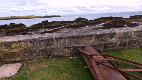 coastal view with lighthouse and old rusty pipe