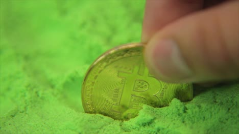 fingers placing bitcoin in a sea of green