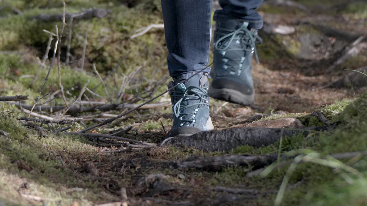 movimiento lento de una persona caminando con cuidado con zapatos de senderismo en el camino del bosque en el bosque