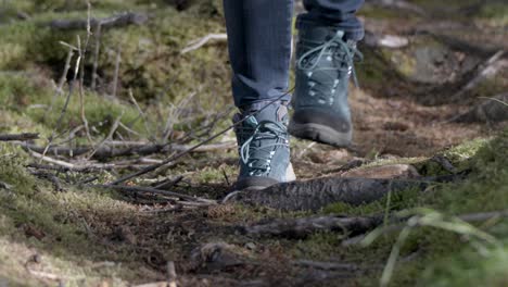 slow motion of a person walking carefully with hiking shoes on forest pathway in the forest