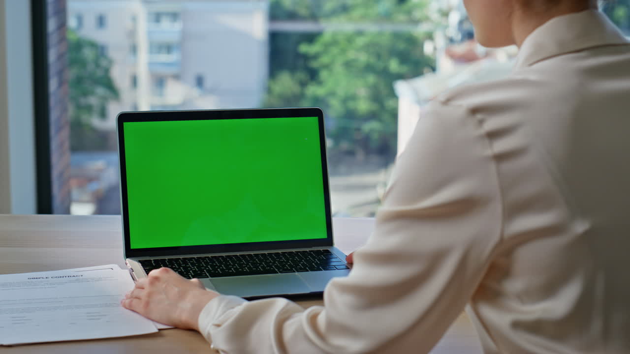 Woman using mockup laptop for online research in corporate office closeup