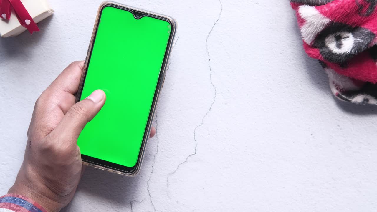 persona que usa un teléfono inteligente de pantalla verde con café y una caja de regalos