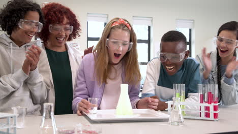 conducting science experiment, multiracial students and female teacher in goggles in laboratory