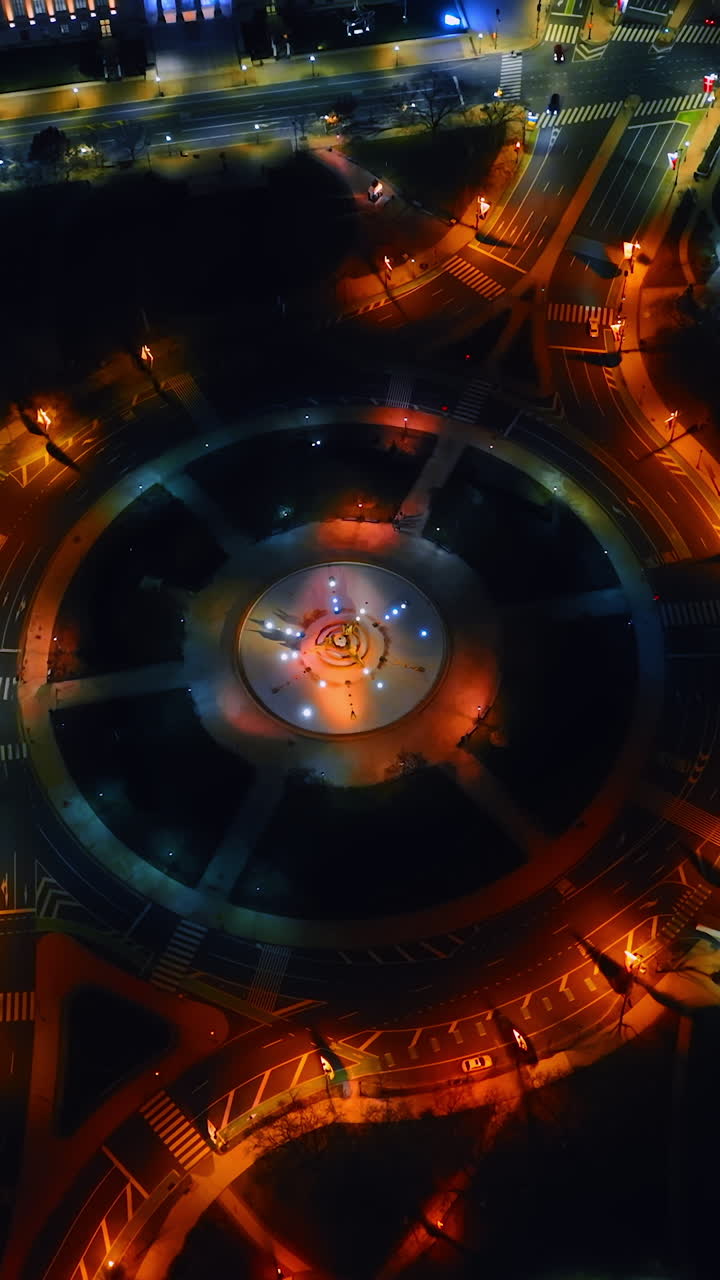 Round square highlighted with orange and yellow light at night. Downtown of Philadelphia, Pennsylvania from aerial perspective. Vertical video