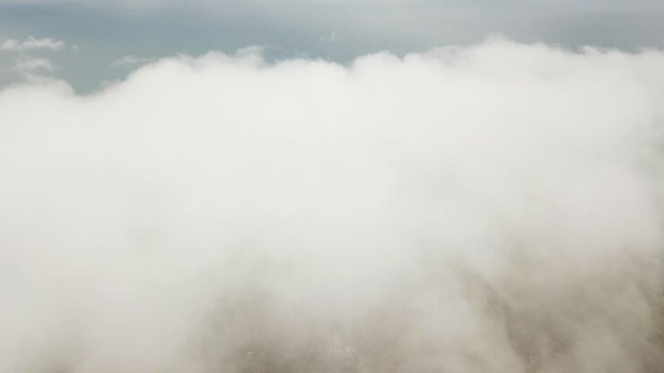 Drone aerial flying towards and into white clouds