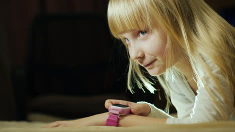 the child talks with the help of children's smart watches lying on the bed in my bedroom