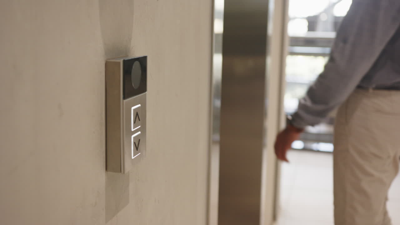 Pressing elevator button, business person waiting for elevator in office building