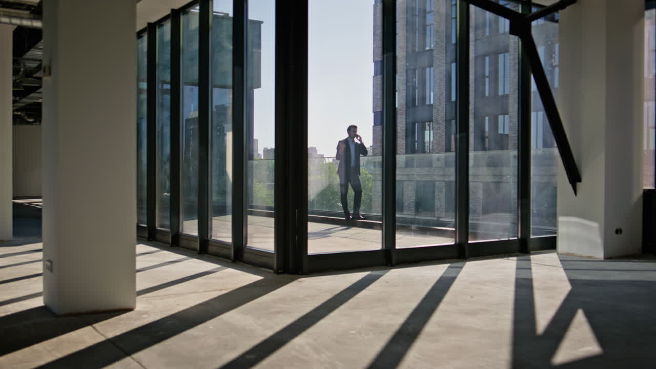 Boss silhouette speaking cellphone at modern architecture building. Man calling