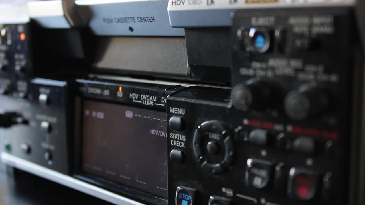 Hand Inserts and Ejects Video Cassette from Professional HDV DVCAM Deck