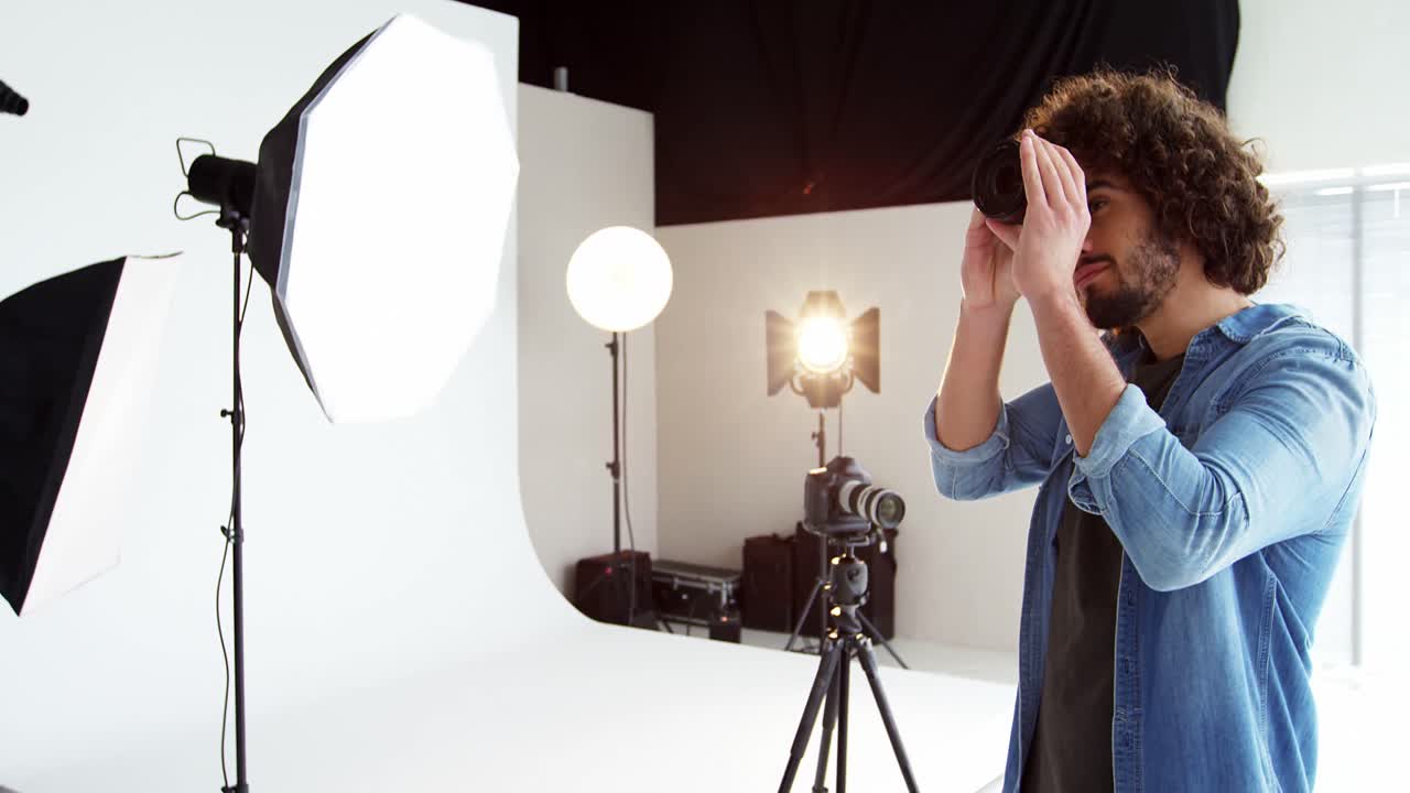 fotógrafo chequeando la lente de la cámara