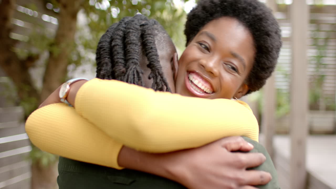 Coppia afroamericana felice che si abbraccia e si gode un caldo abbraccio all'aperto