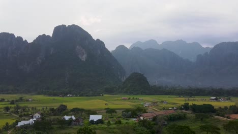 Malerische-Aussicht-über-Die-Felder-Von-Vang-Vieng-Mit-Bergen-Im-Hintergrund