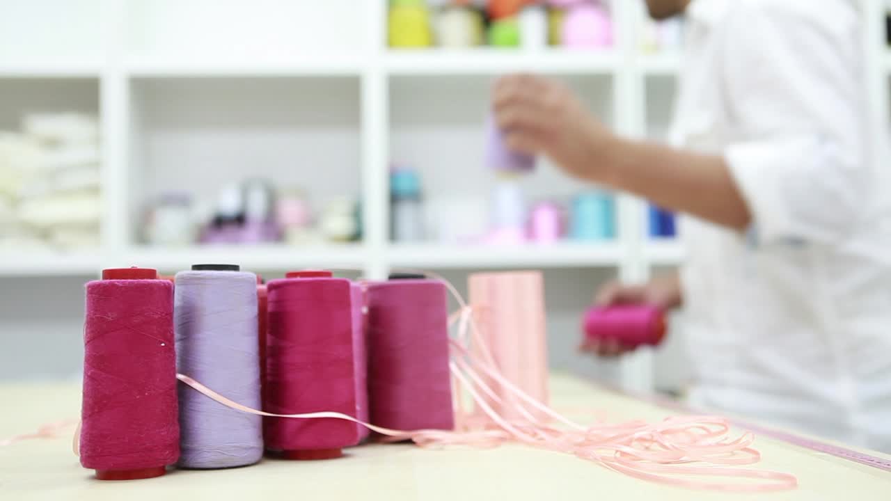 el sastre toma el rollo de hilo de algodón 3