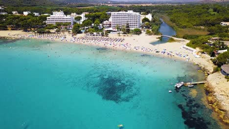 Concurrida-Playa-De-Canyamel-Con-Aguas-Turquesas-En-Un-Día-Soleado,-Mallorca,-España,-Vista-Aérea