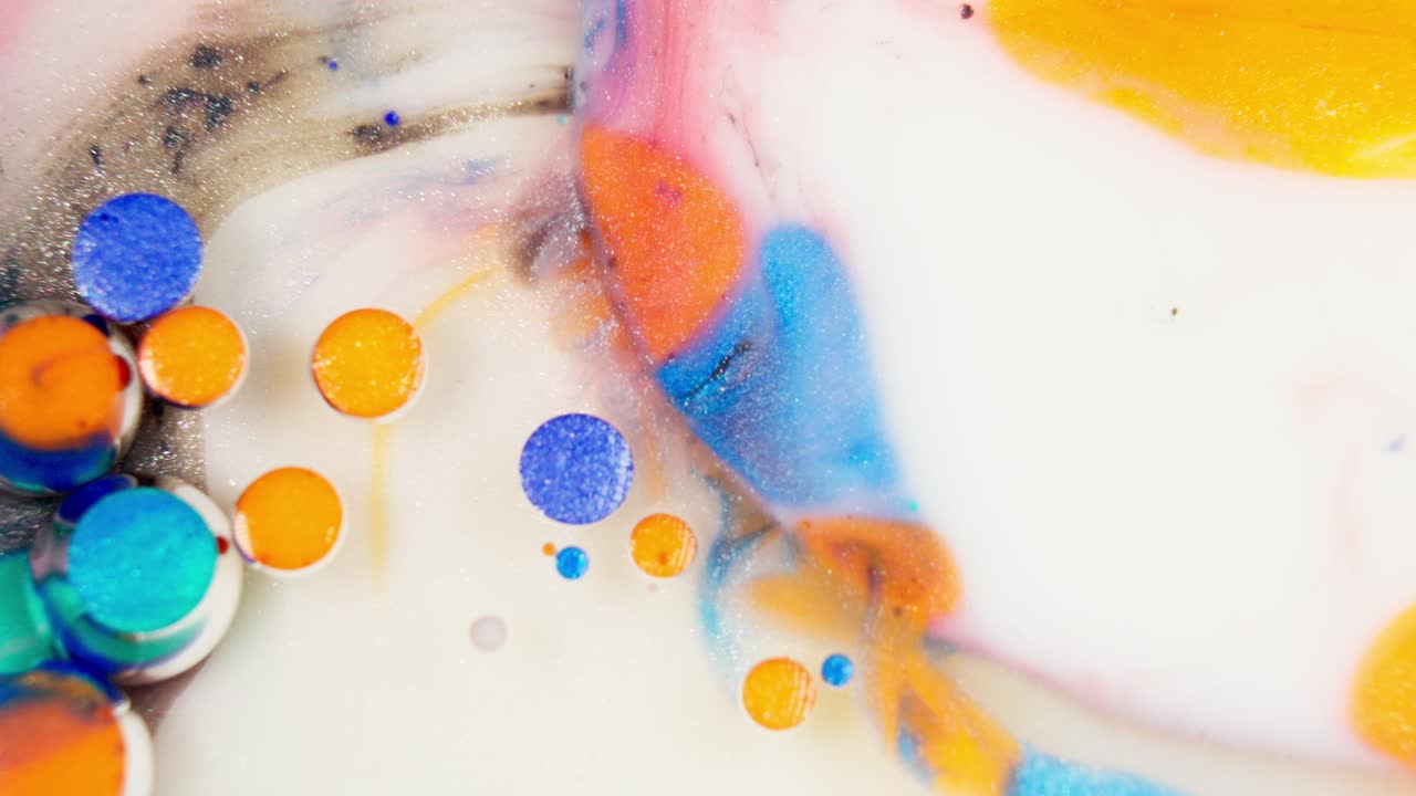 Soluble color tablets dissolving, swirling liquid ink abstract pattern.