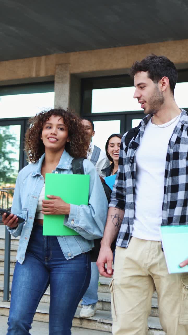 Gruppo eterogeneo di studenti che camminano e parlano sulle scale dell'università.