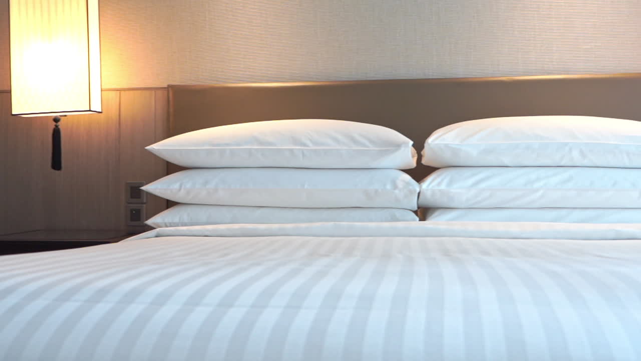 recorre la cama de una suite de hotel llena de cómodas almohadas