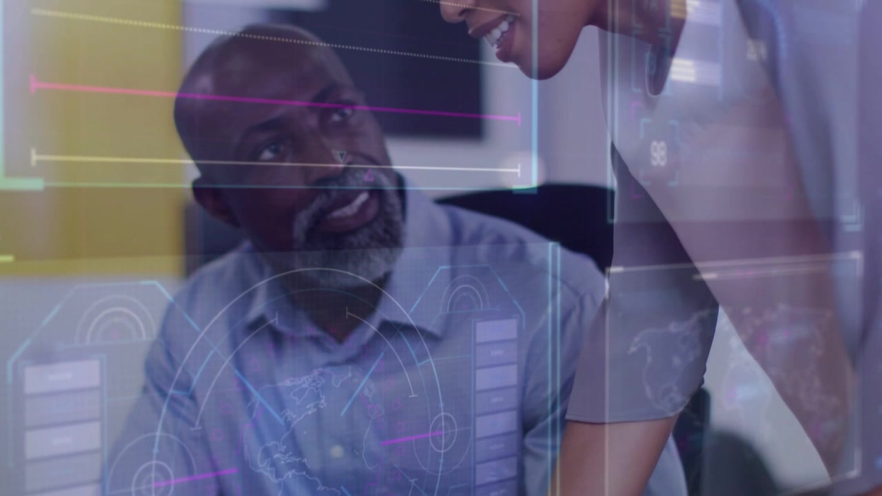Mature man pausing typing and gesturing mid adult woman leaning HUD charts clarifying business data