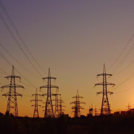 silhouette of high-voltage towers. electricity pylons on energy station on the background of beautiful sky at sunset. electricity station and high-voltage power lines.view from below.