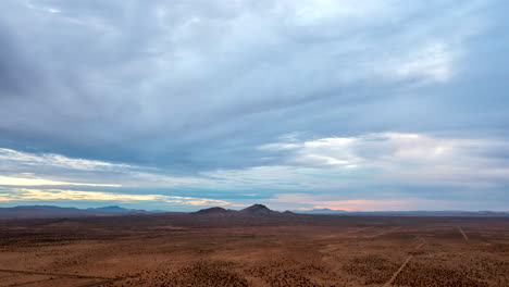 cuenca del desierto de mojave y paisaje con las montañas a lo lejos y un paisaje nublado sobre la cabeza - hiperlapso aéreo panorámico