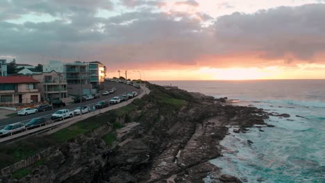 Ciudad-Junto-A-La-Playa-En-El-Promontorio-Al-Amanecer---Drone-4k