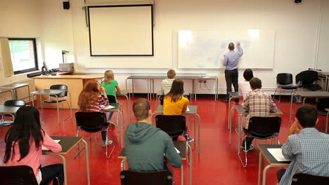 profesor escribiendo en la pizarra en clase