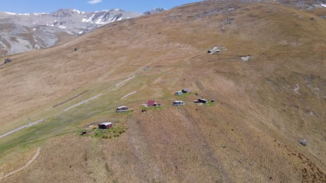 Varias-Cabañas-En-Un-Lado-Cubierto-De-Hierba-De-Una-Montaña