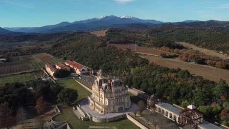 aerial view of a historic chateau estate with mountain background