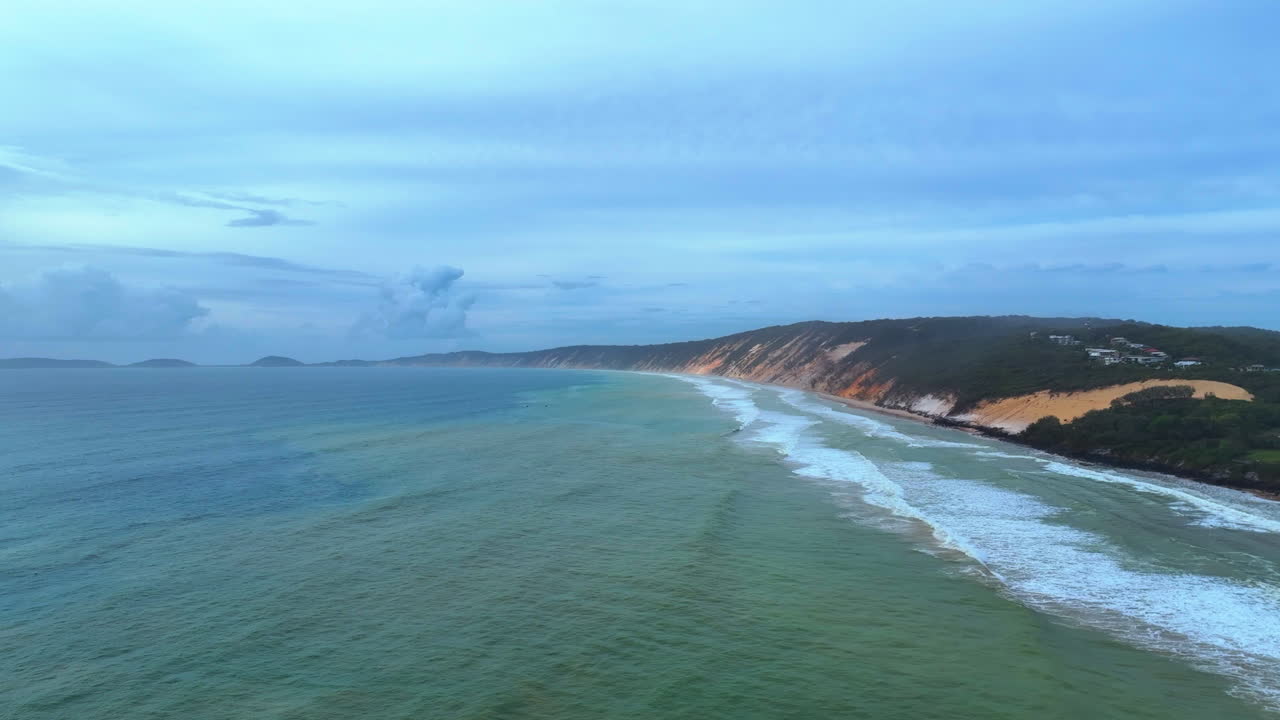 aerial captura la atmósfera temperamental y misteriosa de la costa que se extiende desde la arena de la playa del arco iris hasta el punto de la isla doble en el gran parque nacional de arena de queensland