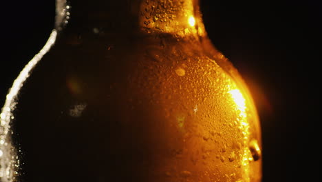 primer plano de una botella de vidrio con gotas de concepto de bebida fría de agua condensada sobre un fondo negro 4k