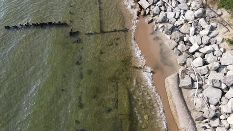 Wasser,-Das-Sanft-Gegen-Einen-Handgefertigten-Damm-Am-Ufer-Des-Michigansees-Schwappt