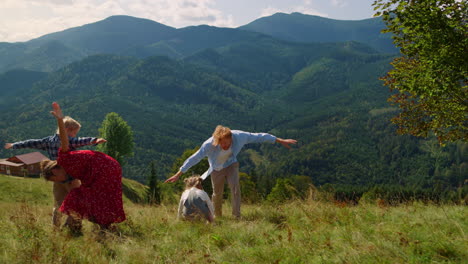 parents enjoy funny games with children at mountains meadow. family playing.