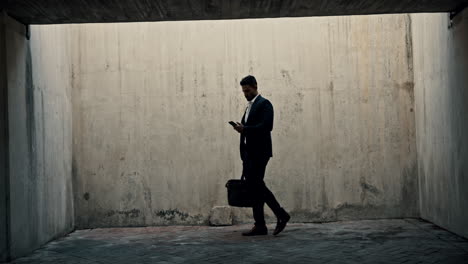 businessman walking in urban tunnel
