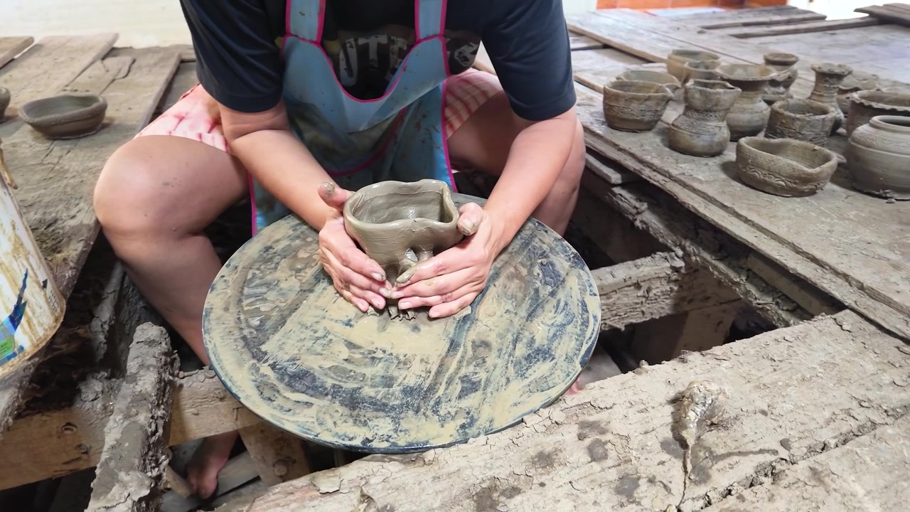 Mani artigiane modellano argilla bagnata su un tornio in un laboratorio di ceramica tradizionale thailandese