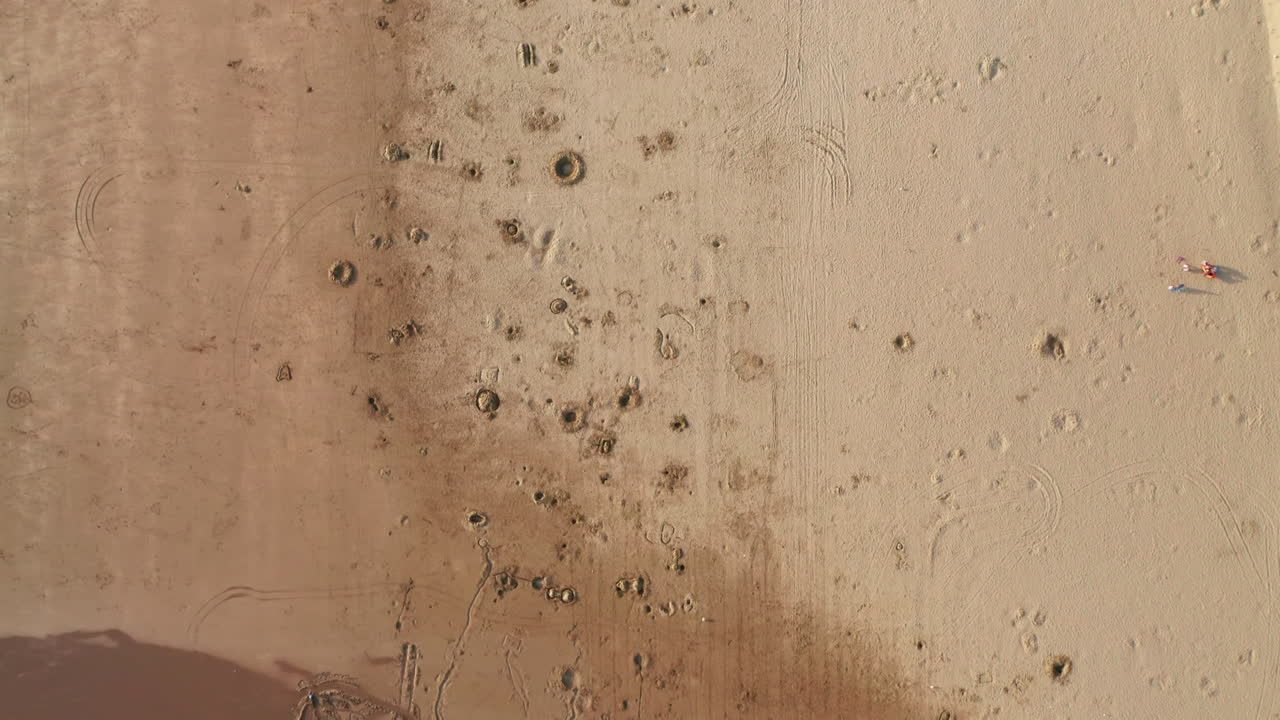 воздушная съемка песчаного пляжа с ямами и автостоянки на закате