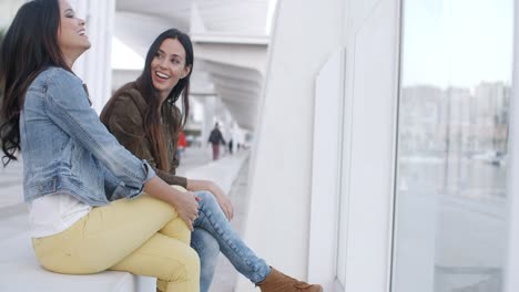 dos mujeres jóvenes de moda relajantes
