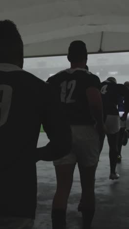 male rugby players running together in a row at the entrance of stadium 4k