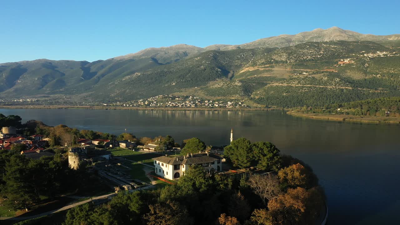 The Turkish mosque of Ioannina in the middle of Lake Pamvotis bordered by the Periochi Oikoanaptixis Nature Park in Ioannina, Epirus, Greece, in summer.