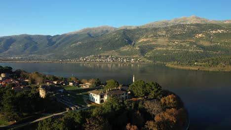 la mezquita turca de ioannina en el medio del lago pamvotis bordeado por el parque natural periokhi oikanaptis en ioannina, epirus, grecia, en verano.