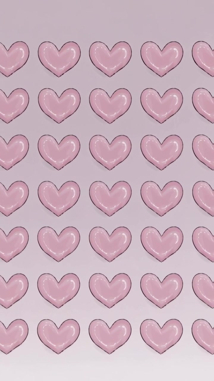 Vertical video: Pulling back camera revealing repeating glossy pink heart grid on vertical canvas