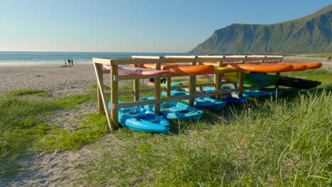 stand up paddle boards and boat at flakstad beach with a scenic view in lofoten, panning shot