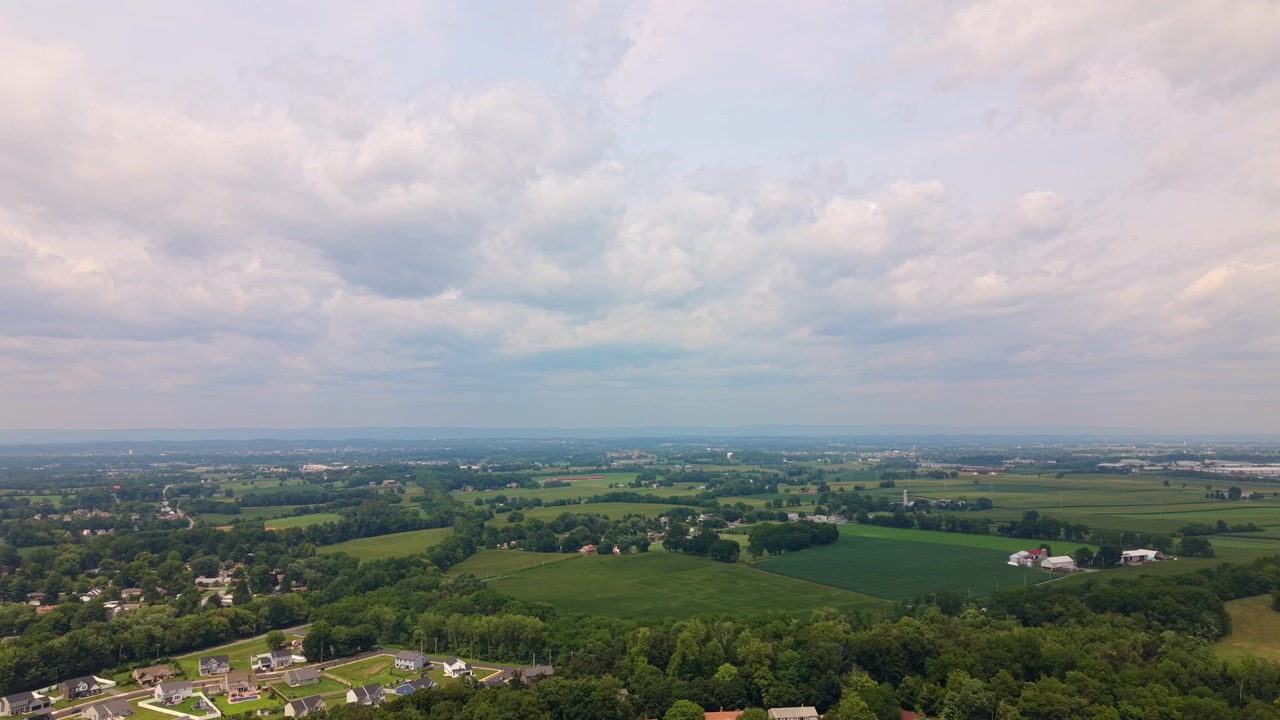 Drone footage flying high over vast woodland hills and dense green tree canopy under overcast sky conditions.