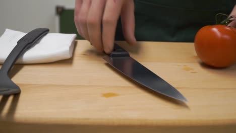 chef cutting a tomato