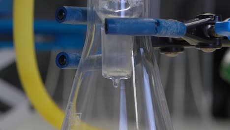 equipo químico, primer plano del líquido que gotea en un matraz receptor durante la destilación