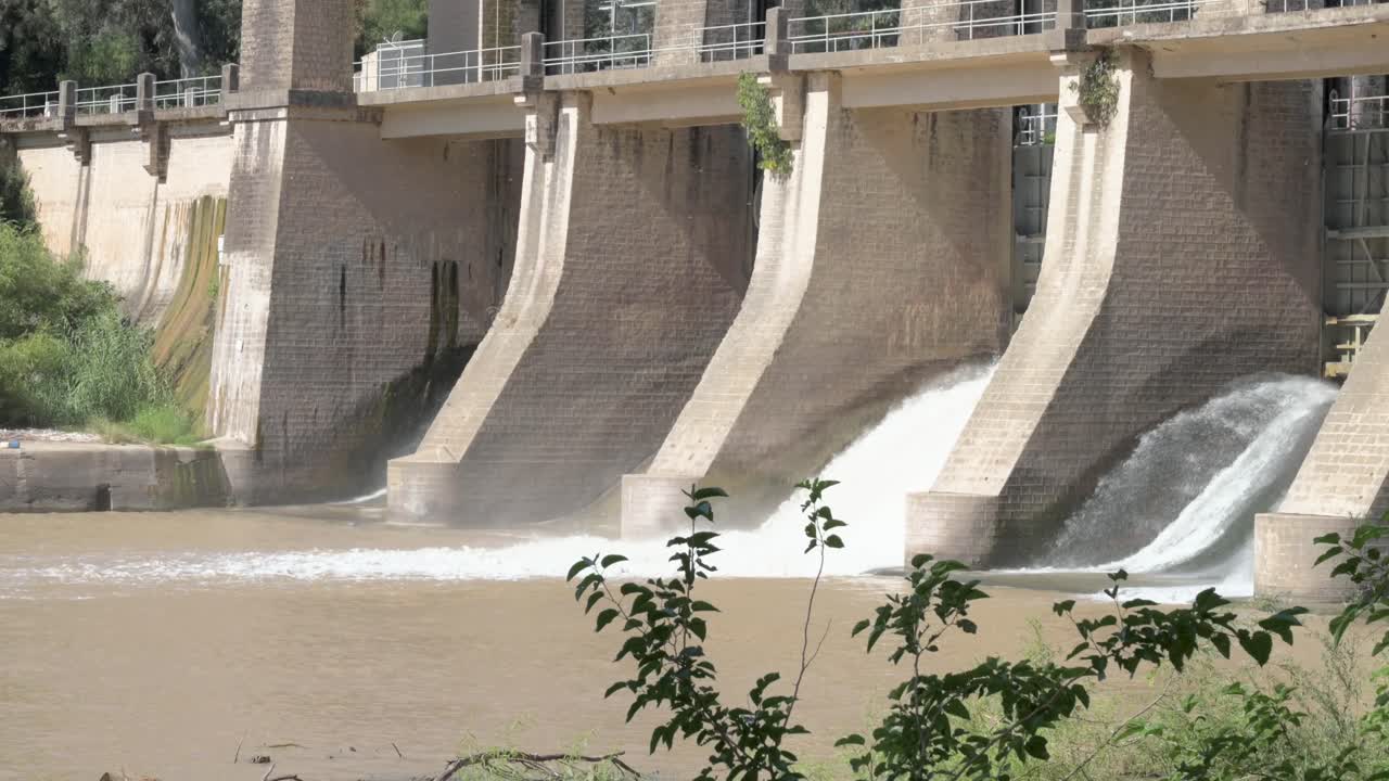 Close-up of an architectural construction of a dam on the Guadalquivir river with the sluice gates open