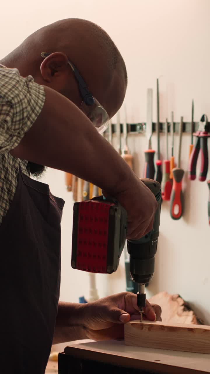 Focused Carpenter Screwing Wood with a Drill in Workshop