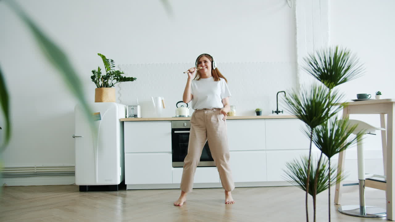 Donna che canta e balla in una cucina moderna