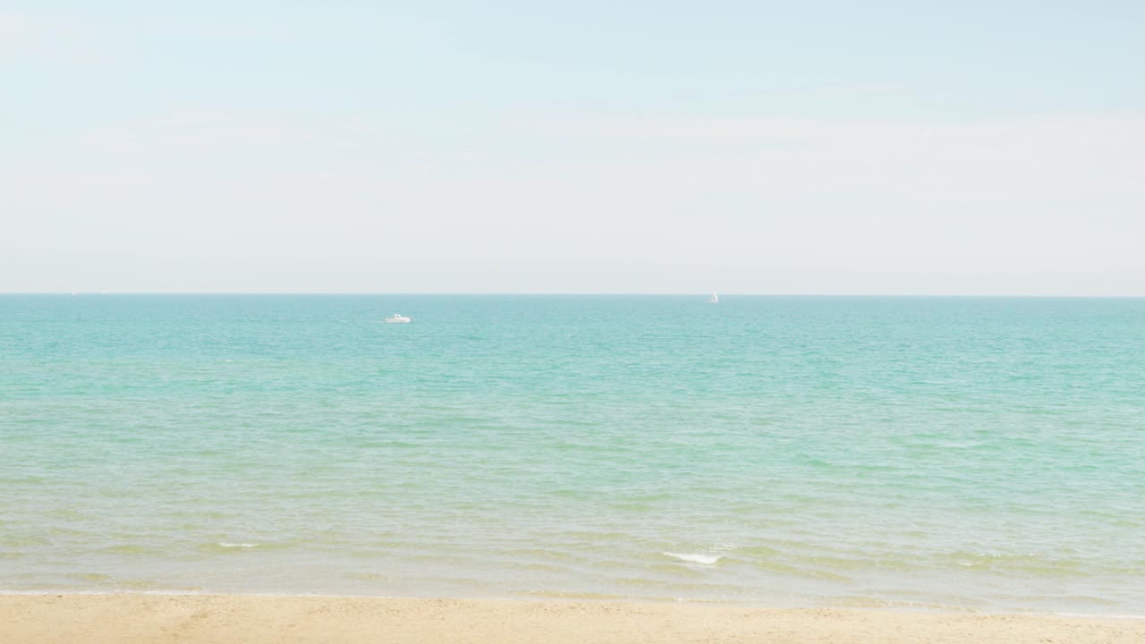 화려한 청록색 지중해 바다가 내려다보이는 해변에 서 있는 남녀 2명