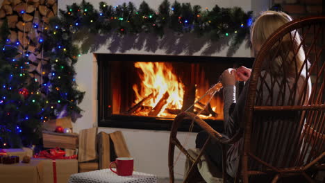 noche junto a la chimenea en la víspera de navidad una anciana teje ropa de abrigo 4k video