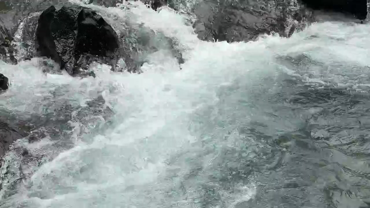 Limpido torrente di montagna che scorre su rocce scure